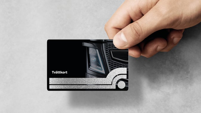 Hand som håller ett Volvo Tvättkort. Bild.
